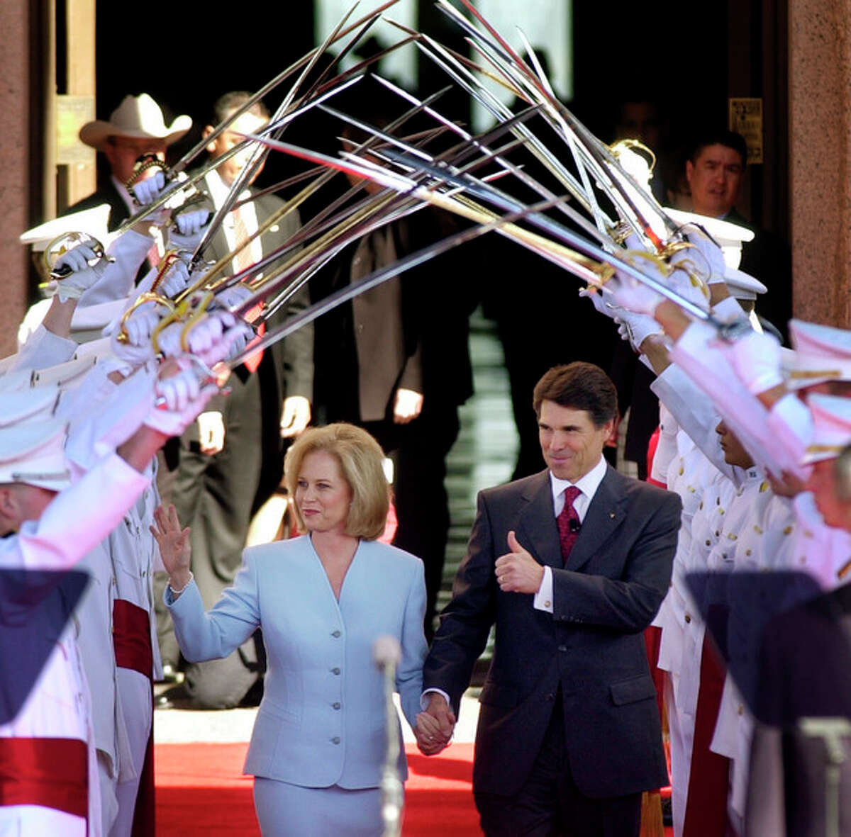 FILE - In this Jan. 21, 2003, file photo Texas Gov. Rick Perry, with his wife Anita, walks under the Ross Volunteers saber arch during Perry's inauguration in Austin, Texas. Perry announced Monday, July 8, 2013, that he would not seek re-election as Texas governor next year. (AP Photo/Eric Gay, File)
