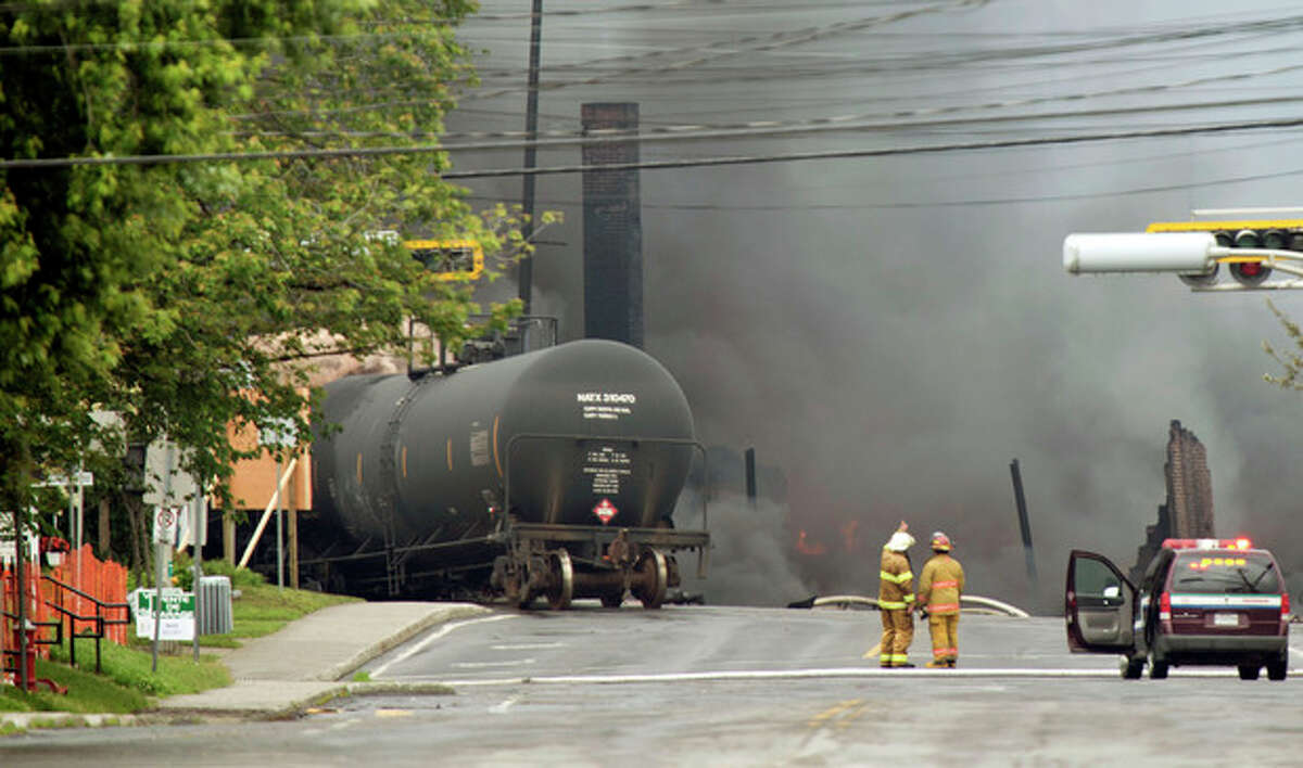 Smoke rises from railway cars that were carrying crude oil after derailing in downtown Lac Megantic, Quebec, Canada, Saturday, July 6, 2013. The derailment sparked several explosions and forced the evacuation of up to 1,000 people. (AP Photo/The Canadian Press, Paul Chiasson)