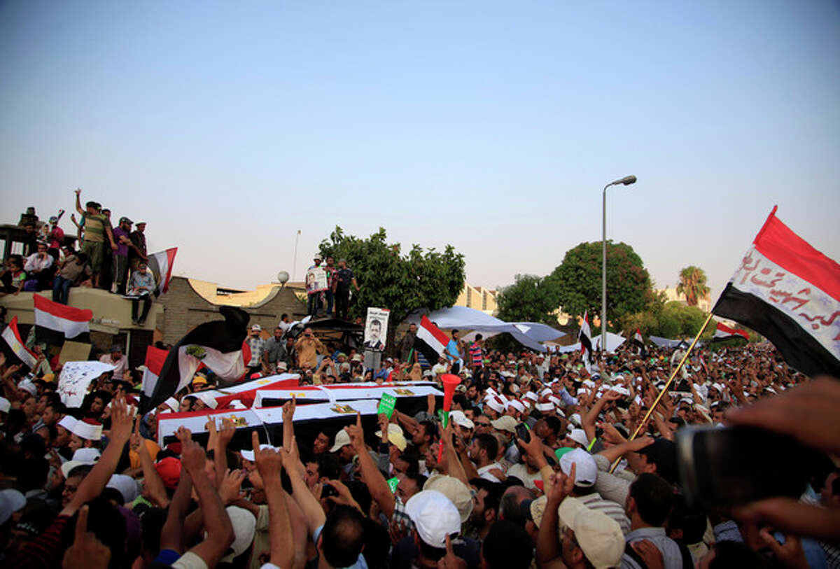Supporters of Egypt's ousted President Mohammed Morsi carry coffins, covered with the national flag, of four men killed after Egyptian troops opened fire on mostly Islamist protesters marching on a Republican Guard headquarters Friday, in Cairo, Saturday, July 6, 2013. (AP Photo/Khalil Hamra)