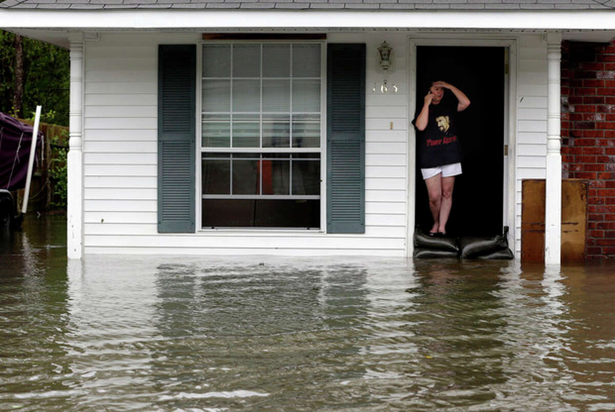 A resident whose home is surrounded by flood waters talks on the phone, Thursday, Aug. 30, 2012, in LaPlace, La. Isaac has caused major flooding in the region. (AP Photo/Eric Gay)