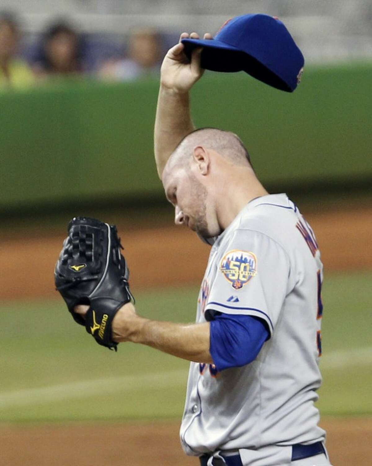 New York Mets' Jeremy Hefner wipes his face after walking Miami Marlins' Justin Ruggiano in the third inning of a baseball game in Miami, Saturday, Sept. 1, 2012. (AP Photo/Alan Diaz)