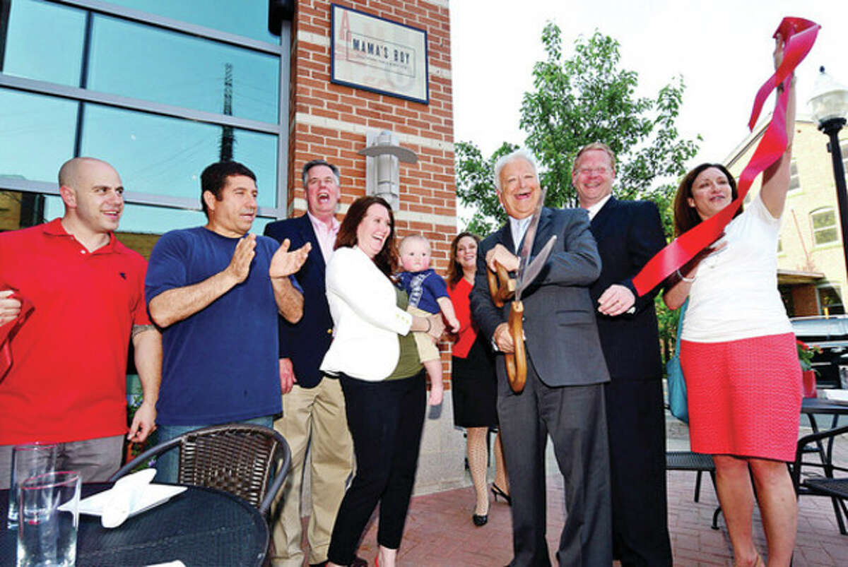John Lunghi and Amiel Dorel of Mama's Boy, Greater Norwalk Chamber of Commerece president Ed Musante, Mama's Boy owner Greer Frederick's with her son, Jax, Stacey Hascoe, assistant director of the SONO Corporate, Norwalk Mayor Richard Moccia, Councilman David McCarthy and Norwalk Parking Authority Director Kathryn Hebert, cut the ribbon for the new Mama's Boy restaurant on North Water Street Thursday. Center Hour photo / Erik Trautmann