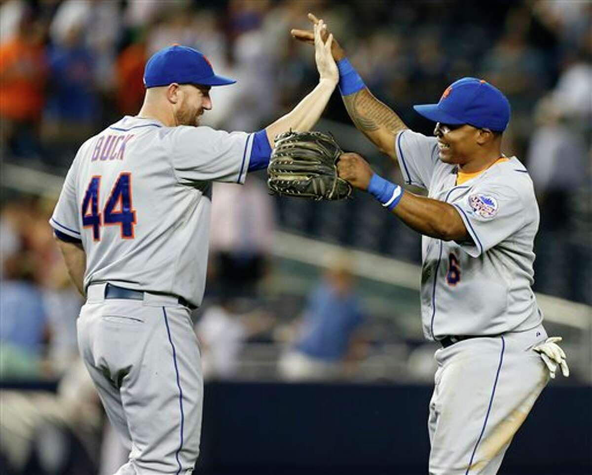 CORRECTS BUCK'S POSITION - New York Mets right fielder Marlon Byrd, right, celebrates with designated-hitter John Buck (44) after the the Mets defeated the New York Yankees 3-1 to complete a four game sweep after an interleague baseball game series at Yankee Stadium in New York, Thursday, May 30, 2013. (AP Photo/Kathy Willens)