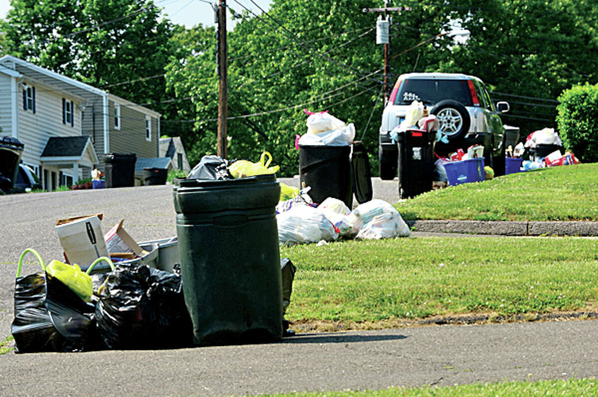 Trash lines the curb on Ferris Ave after trash that was due for pick up Tuesday was still out Thursday afternoon. Hour photo / Erik Trautmann