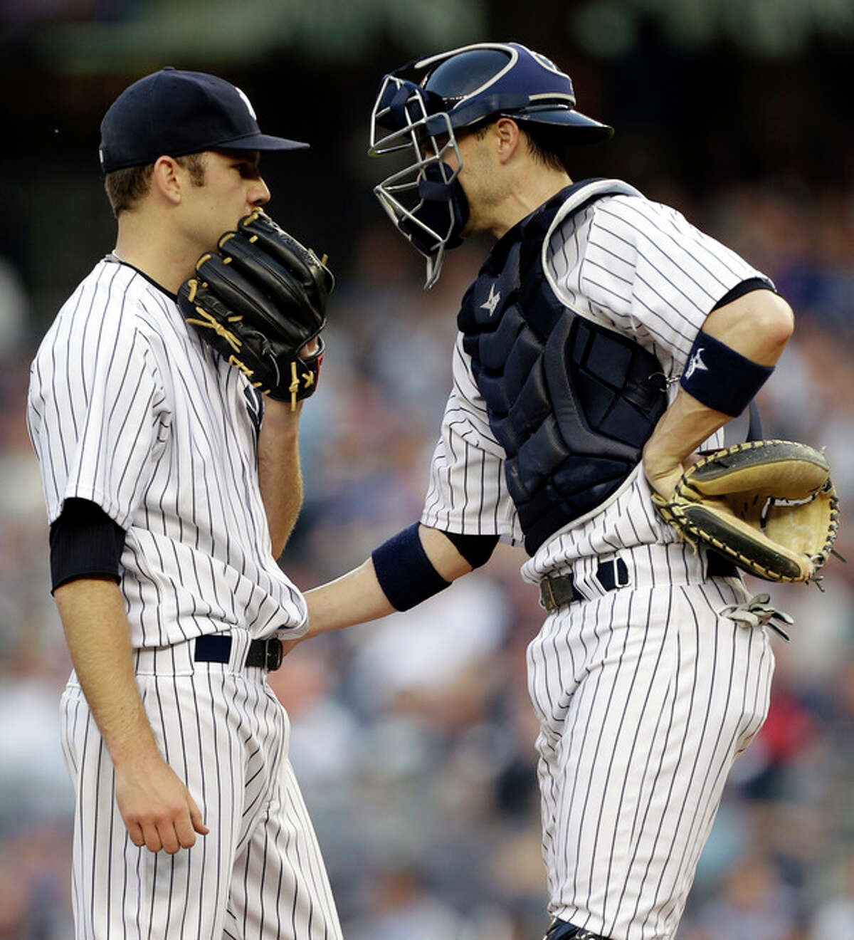 New York Yankees catcher Chris Stewart, right, talks with starting pitcher David Phelps in the first inning of in an interleague baseball game against the New York Mets at Yankee Stadium in New York, Wednesday, May 29, 2013. Phelps allowed five runs and registered one out before manager Joe Girardi relieved him from the game. (AP Photo/Kathy Willens)