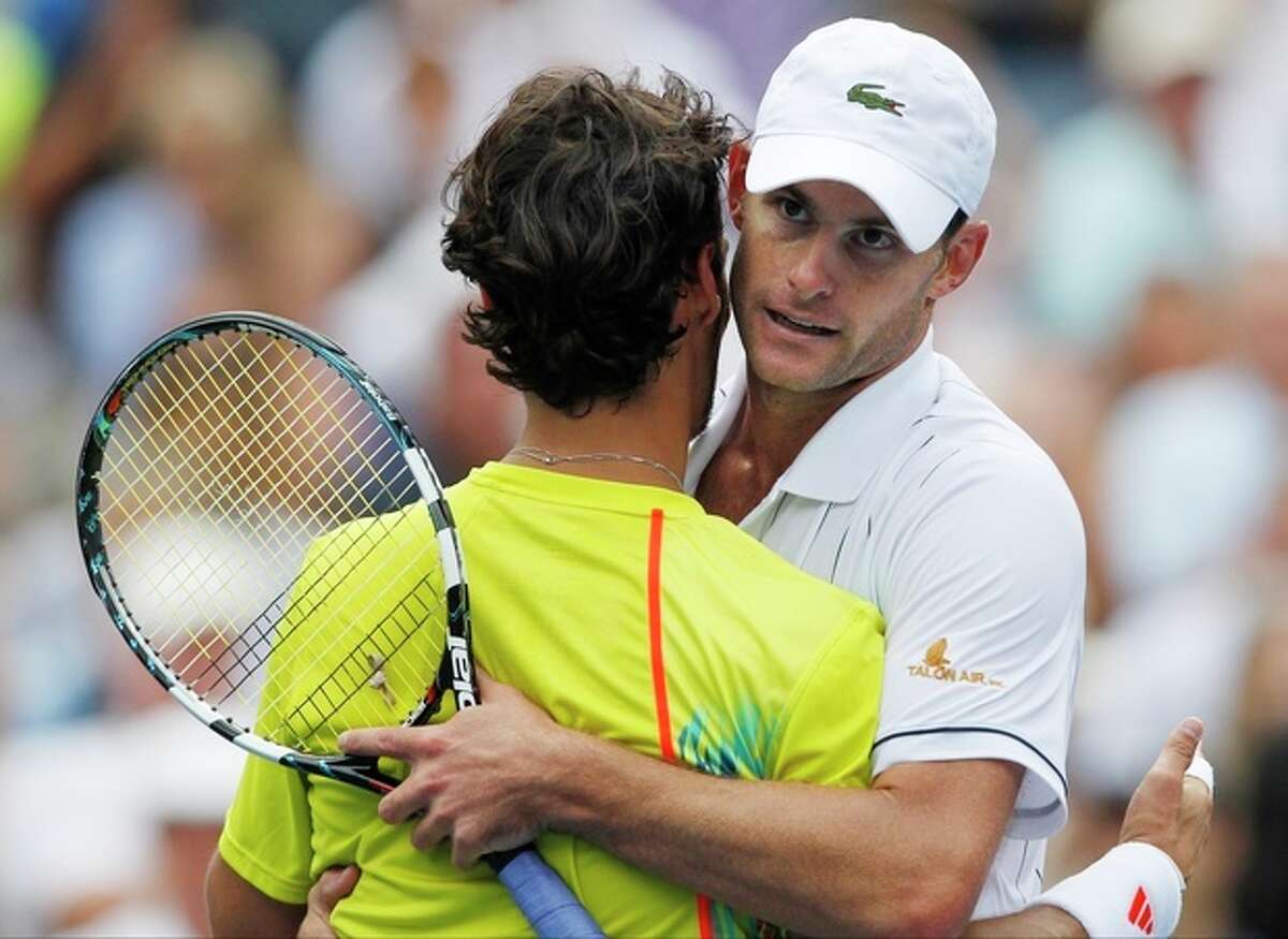 Andy Roddick hugs Italy's Fabio Fognini after their match in the third round of play at the 2012 US Open tennis tournament, Sunday, Sept. 2, 2012, in New York. Roddick won the match. (AP Photo/Mel C. Evans)