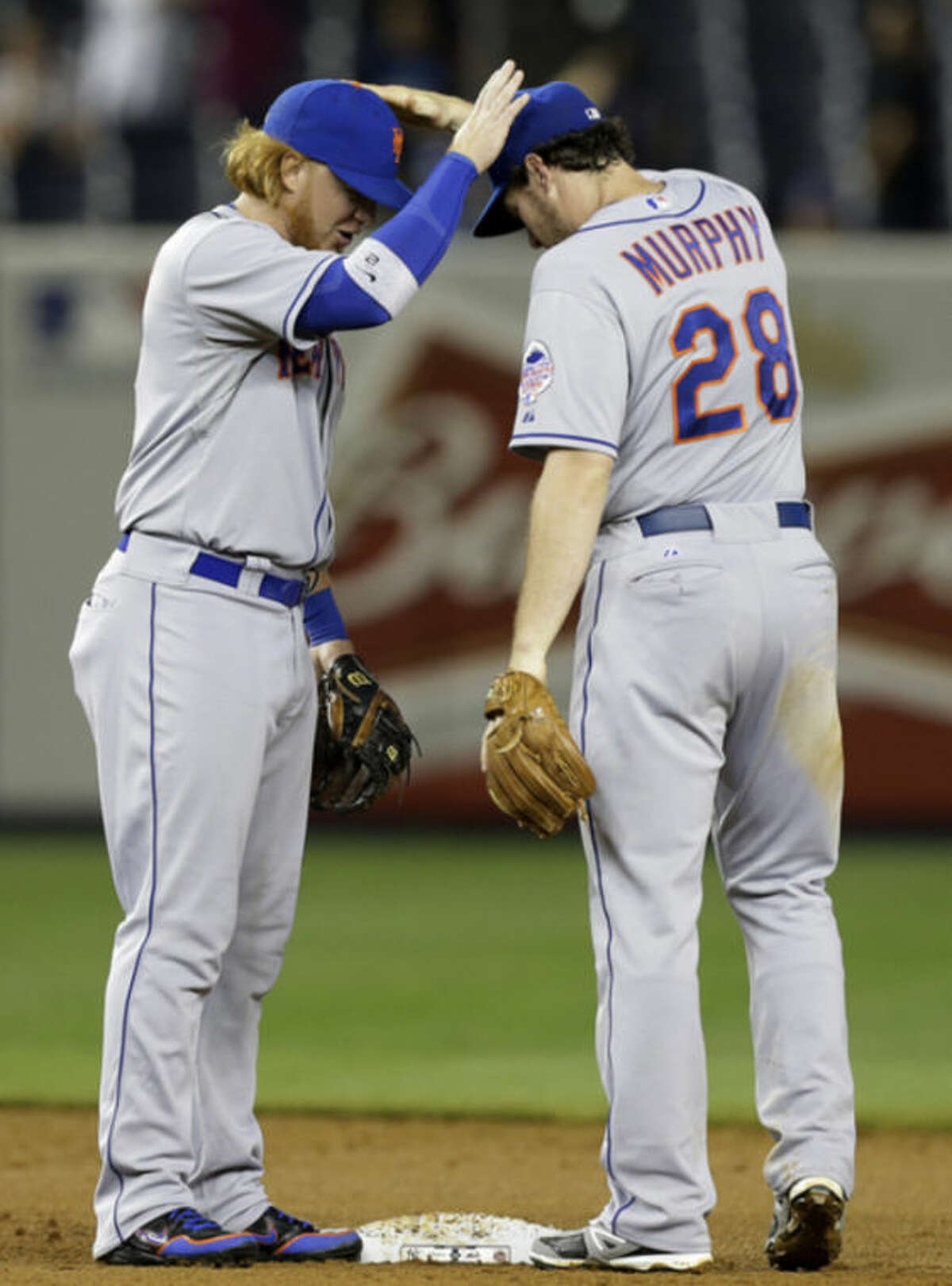 CORRECTS SCORE TO 9-4 NOT 9-3 - New York Mets second baseman Justin Turner (2) congratulates second baseman Daniel Murphy (28) after they defeated the New York Yankees 9-4 in an interleague baseball game at Yankee Stadium in New York, Wednesday, May 29, 2013. (AP Photo/Kathy Willens)