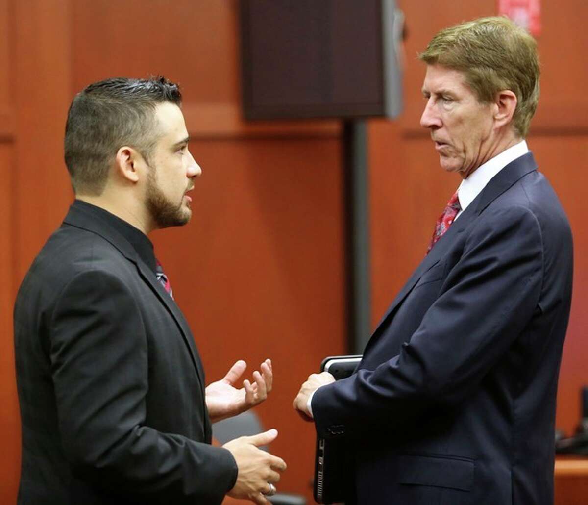 Robert Zimmerman Jr., left, the brother of George Zimmerman, the accused shooter of Trayvon Martin, talks with defense attorney Mark O'Mara, during a pre-trial hearing, Tuesday, May 28, 2013 in Sanford, Fla. George Zimmerman has been charged with second-degree murder for the 2012 shooting death of Trayvon Martin. He was not in court for the hearing. (AP Photo/Orlando Sentinel, Joe Burbank, Pool)