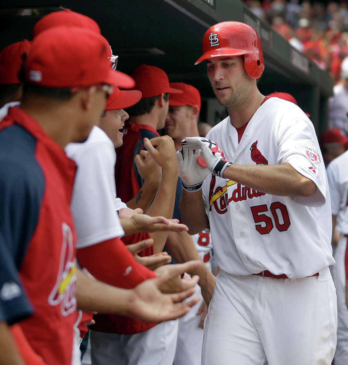 St. Louis Cardinals' Adam Wainwright is congratulated by teammates in the dugout after hitting a solo home run during the third inning of a baseball game against the New York Mets, Wednesday, Sept. 5, 2012, in St. Louis. (AP Photo/Jeff Roberson)