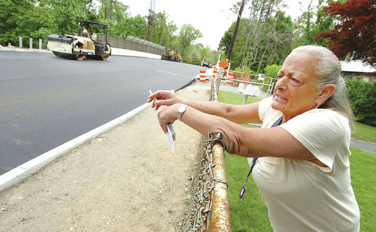 Hour Photo/Alex von Kleydorff Bryne Ramjian a resident of Trinagle street stops after getting her mail as paving continues on the construction project to re build the bridge over the Metro North train tracks starts to wind down.