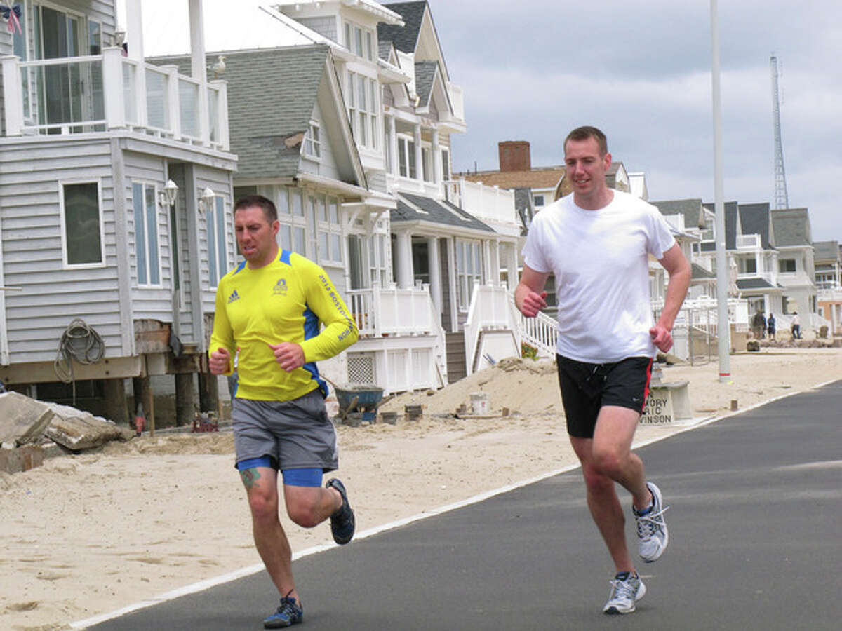 Joggers run past a house damaged by Superstorm Sandy on the Manasquan, N.J., beachfront, Saturday, May 25, 2013. Communities that were hard-hit by Superstorm Sandy, including Manasquan, are hoping for a profitable summer season to help them recover. (AP Photo/Wayne Parry)