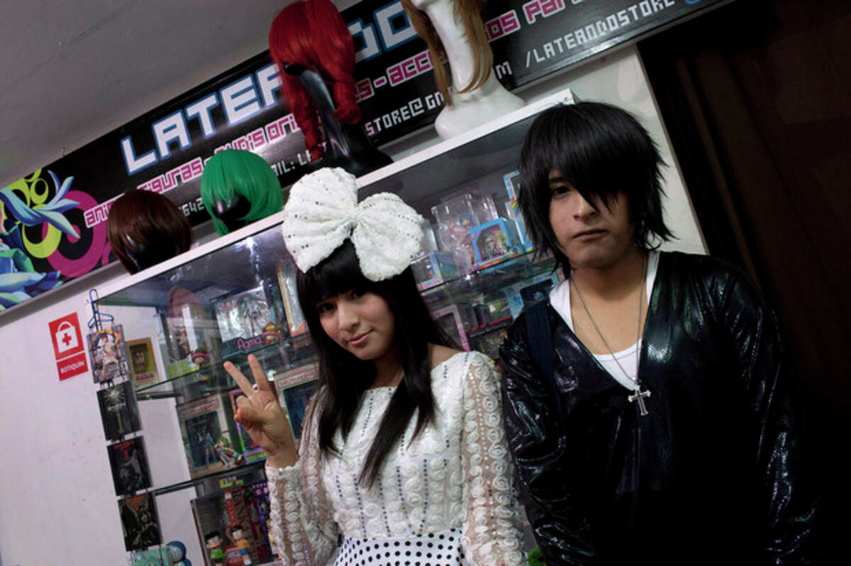 In this May 4, 2013 photo, Sandra and Gabriel, who did not give their last names, pose for a photo in their costumes in the style of characters from South Korean comic books at the Arenales shopping center in Lima, Peru. The Arenales shopping center has entire floors dedicated to South Korean music, clothes and food. (AP Photo/Martin Mejia)