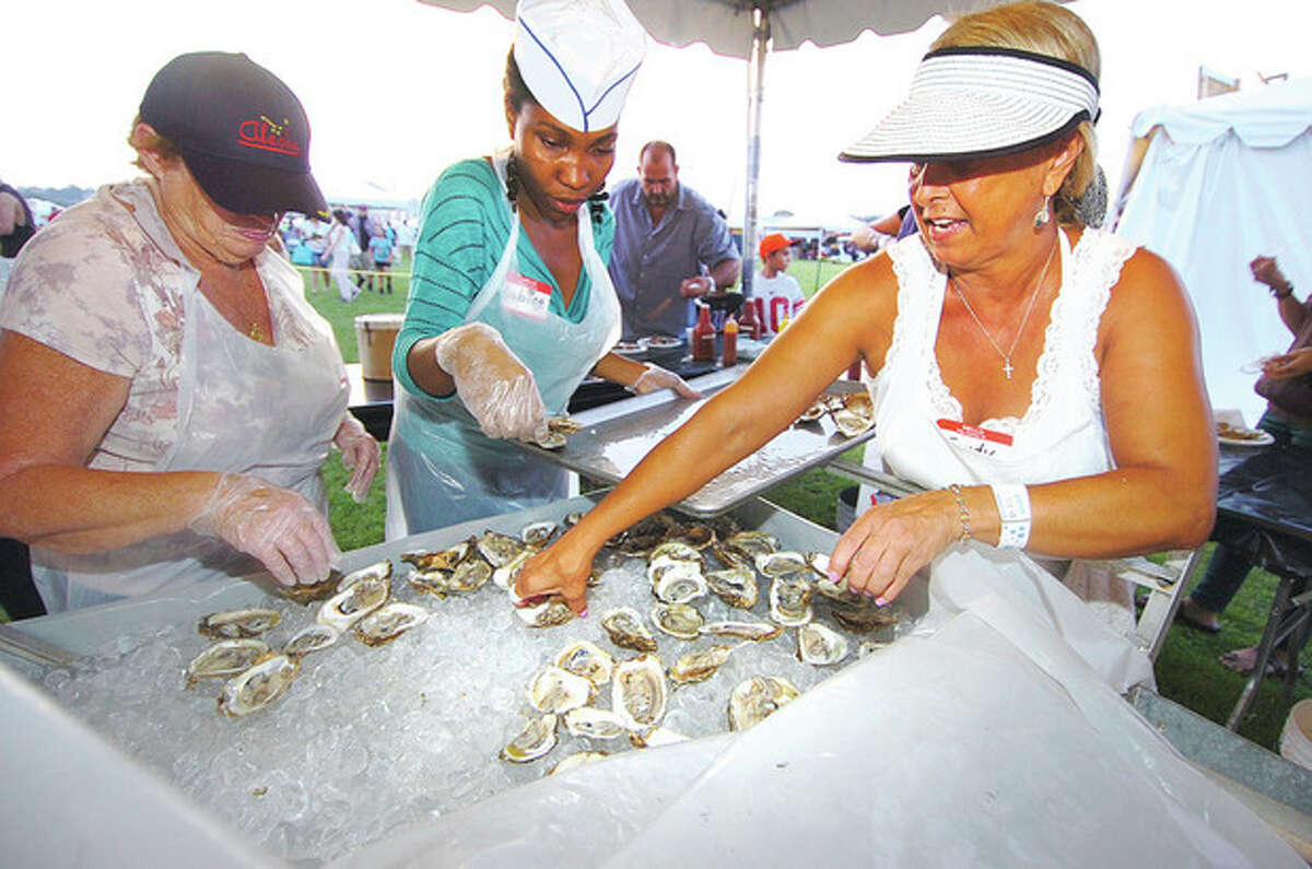 Hour Photo/ Alex von Kleydorff. l-r Mary Tillinghast, Sabine Lezeau and Sandy Schmitt set out more fresh shucked oysters for the crowds at Flotilla 72 at the 2012 Oyster Festival