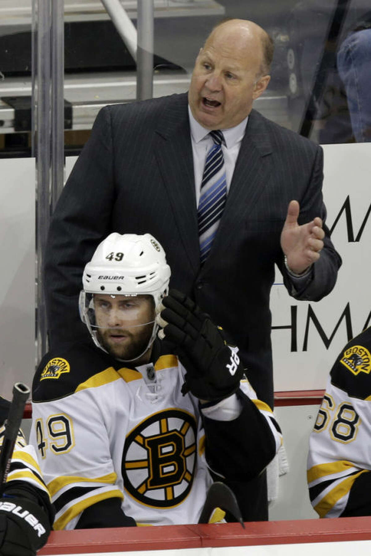 Boston Bruins coach Claude Julien stands behind Rich Peverley (49) in the third period of Game 2 of the NHL hockey Stanley Cup playoffs Eastern Conference finals in Pittsburgh Monday, June 3, 2013. The Bruins defeated the Pittsburgh Penguins 6-1. (AP Photo/Gene J. Puskar)