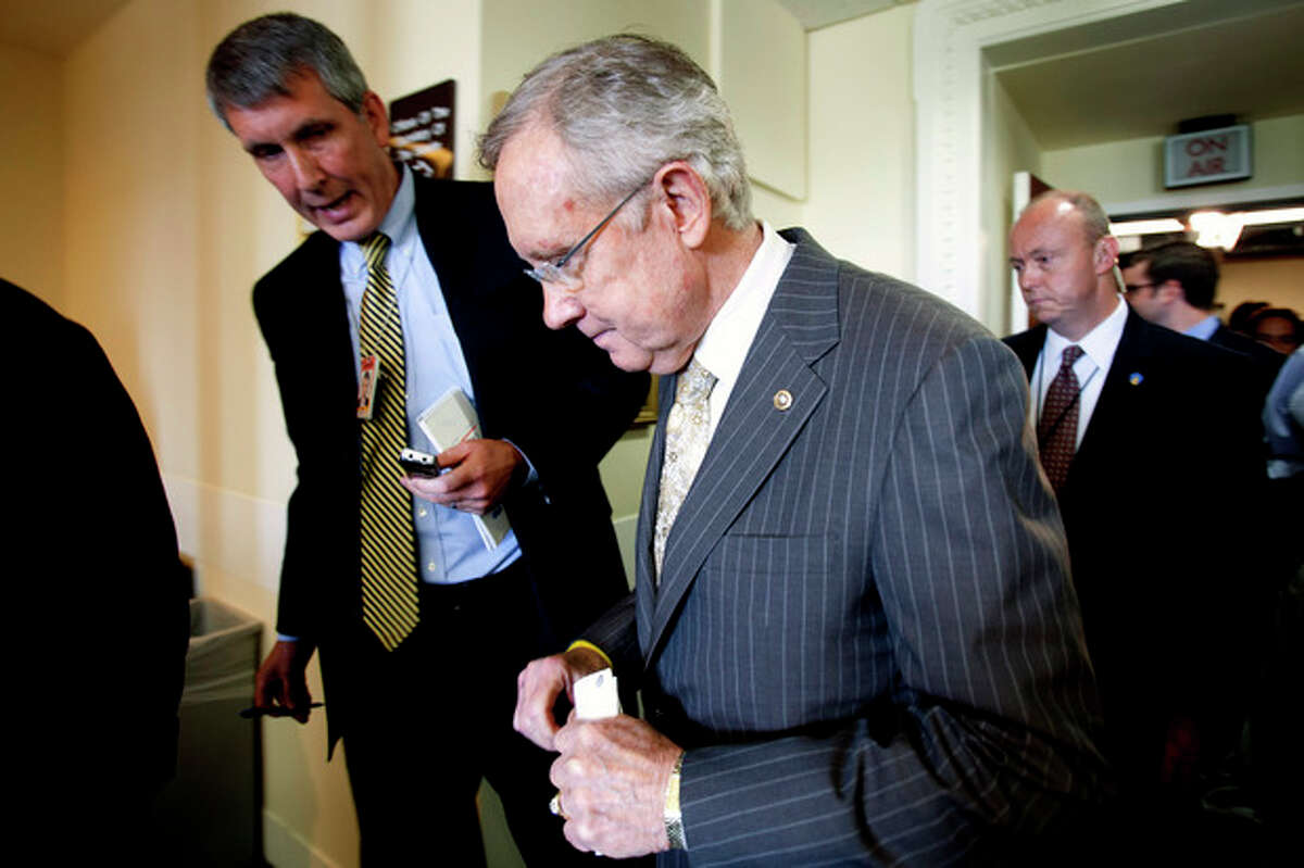 FILE - In this July 12, 2012, file photo Senate Majority Leader Harry Reid of Nevada is pursued by reporters on Capitol Hill in Washington. Fresh off a five-week vacation, lawmakers return to Washington on Monday, Sept. 10, 2012, for a brief pre-election session in which Congress will do what it often does best: punt its problems to the future. At issue is a six-month temporary spending bill to finance the day-to-day operations of the federal government. (AP Photo/Jacquelyn Martin, File)