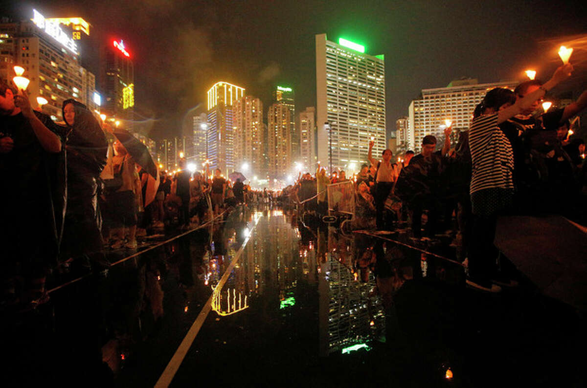 Tens of thousands of people attend a candlelight vigil under heavy rain at Hong Kong's Victoria Park in Hong Kong Tuesday June 4, 2013 to mark the 24th anniversary of the June 4th Chinese military crackdown on the pro-democracy movement in Beijing. (AP Photo/Vincent Yu)