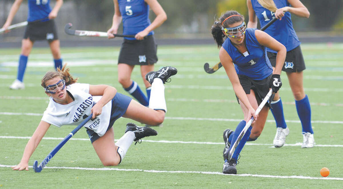 File photo by John Nash Wilton's Madison Hendry, left, goes flying while Darien's Alex Iqbal maintains control of the ball during a game last season. Hendry hits the turf a lot, but always bounces back up.