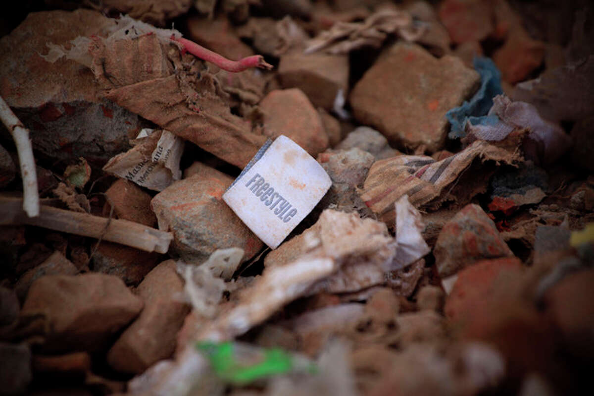 A clothes tag lies in the rubble of a garments factory that collapsed in Savar near Dhaka, Bangladesh, Saturday, May 5, 2013. Officials said Saturday that more than 530 bodies have been pulled from the wreckage of the eight-story Rana Plaza building that collapsed last week, sparking desperate rescue efforts, a national outpouring of grief and violent street protests. (AP Photo/Ismail Ferdous)
