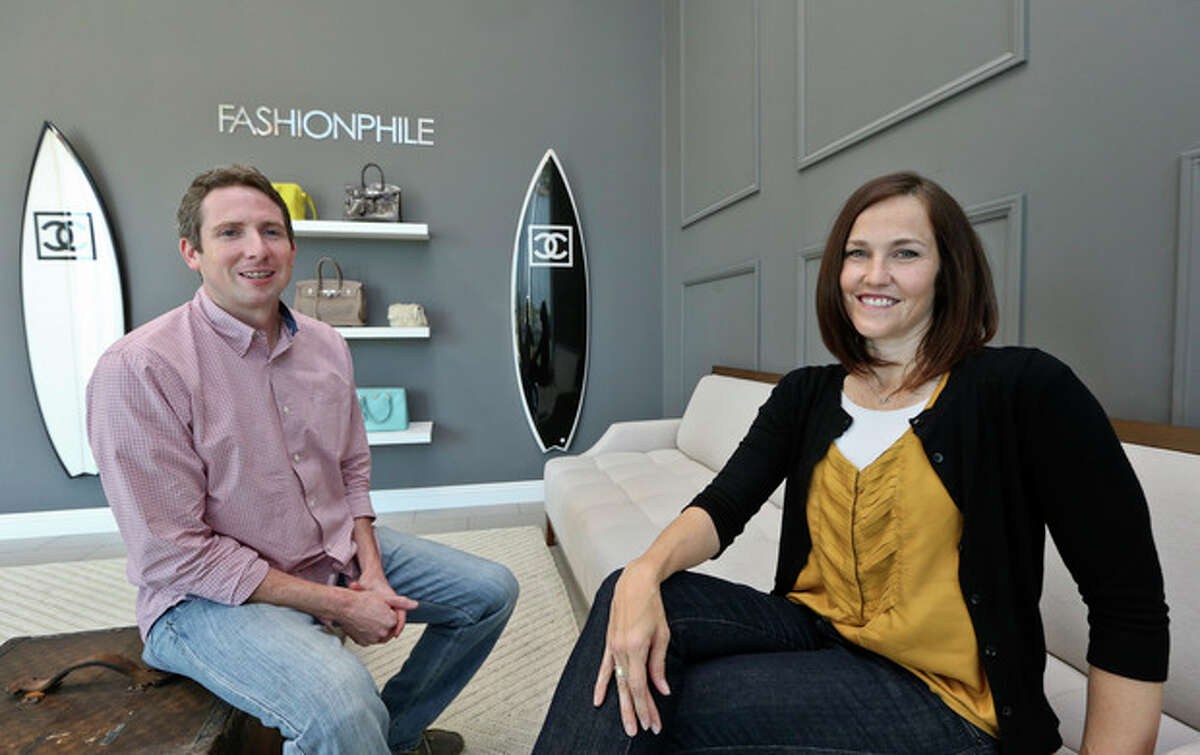 This photo taken May 2, 2013, shows Sarah Davis and Ben Hemmnger, co-owners of Fashionphile.com, posing in the lobby of their Carlsbad, Calif. office. The Internet company sells rare, vintage, and discontinued previous owned bags and is facing the complicated task of dealing with new state regulations on Internet sale taxes. (AP photo/Lenny Ignelzi)
