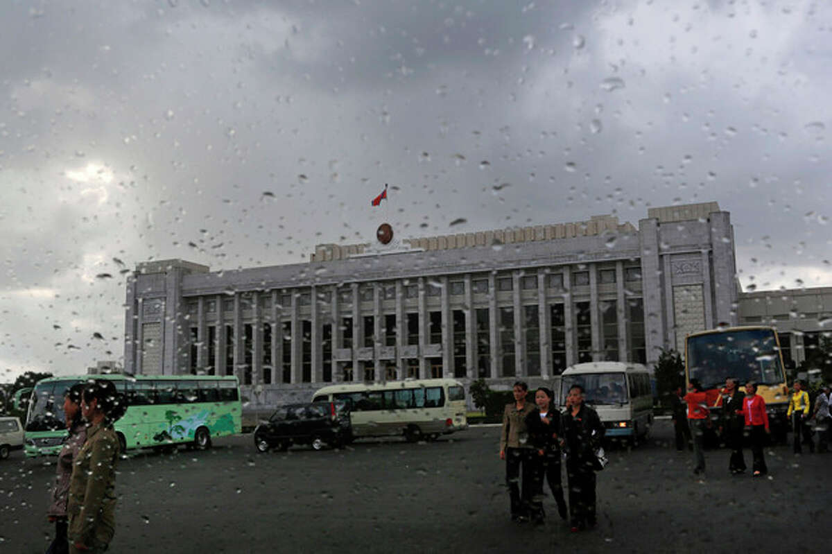In this Sept. 19, 2012 photo, North Koreans walk in front of the Mansudae Assembly Hall in Pyongyang, North Korea. North Korea's rubber-stamp parliament is convening a new session that is drawing attention because it is the second in less than six months. The 687-member Supreme People's Assembly gathers Tuesday, Sept. 25, 2012 in the North Korean capital. (AP Photo/Vincent Yu)