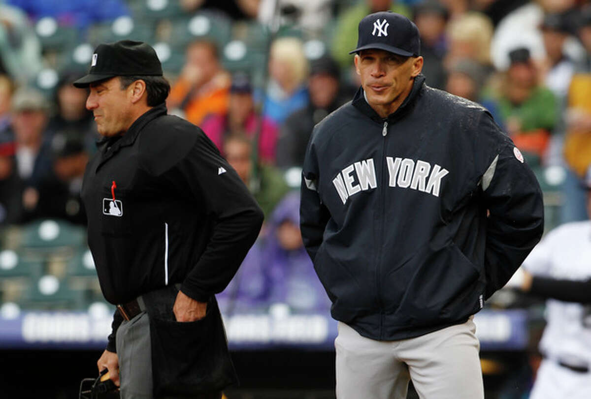 New York Yankees manager Joe Girardi, right, reacts after arguing with home plate umpire Phil Cuzzi, who called Colorado Rockies runner Dexter Fowler safe at home as he scored on a sacrifice fly in the first inning of a baseball game in Denver on Thursday, May 9, 2013. (AP Photo/David Zalubowski)