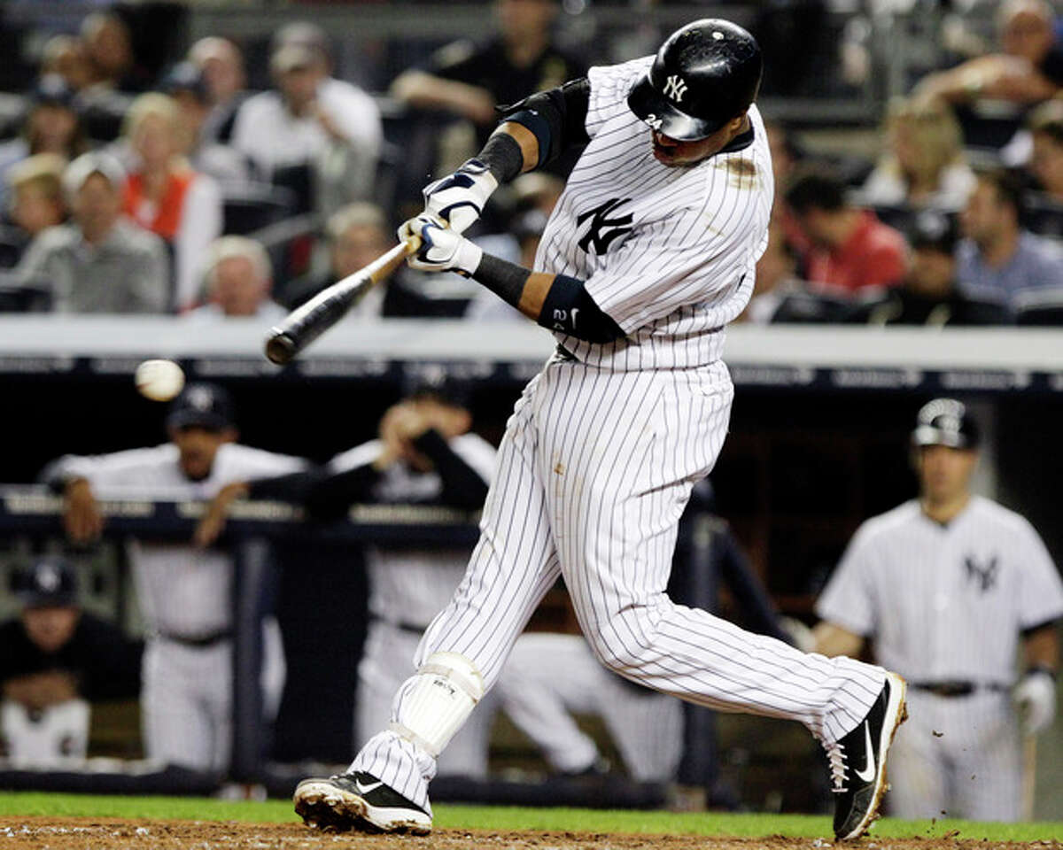 New York Yankees' Robinson Cano hits a two-RBI single during the sixth inning of a baseball game against the Boston Red Sox, Wednesday, Oct. 3, 2012, in New York. Russell Martin and Ichiro Suzuki scored on the hit. (AP Photo/Frank Franklin II)