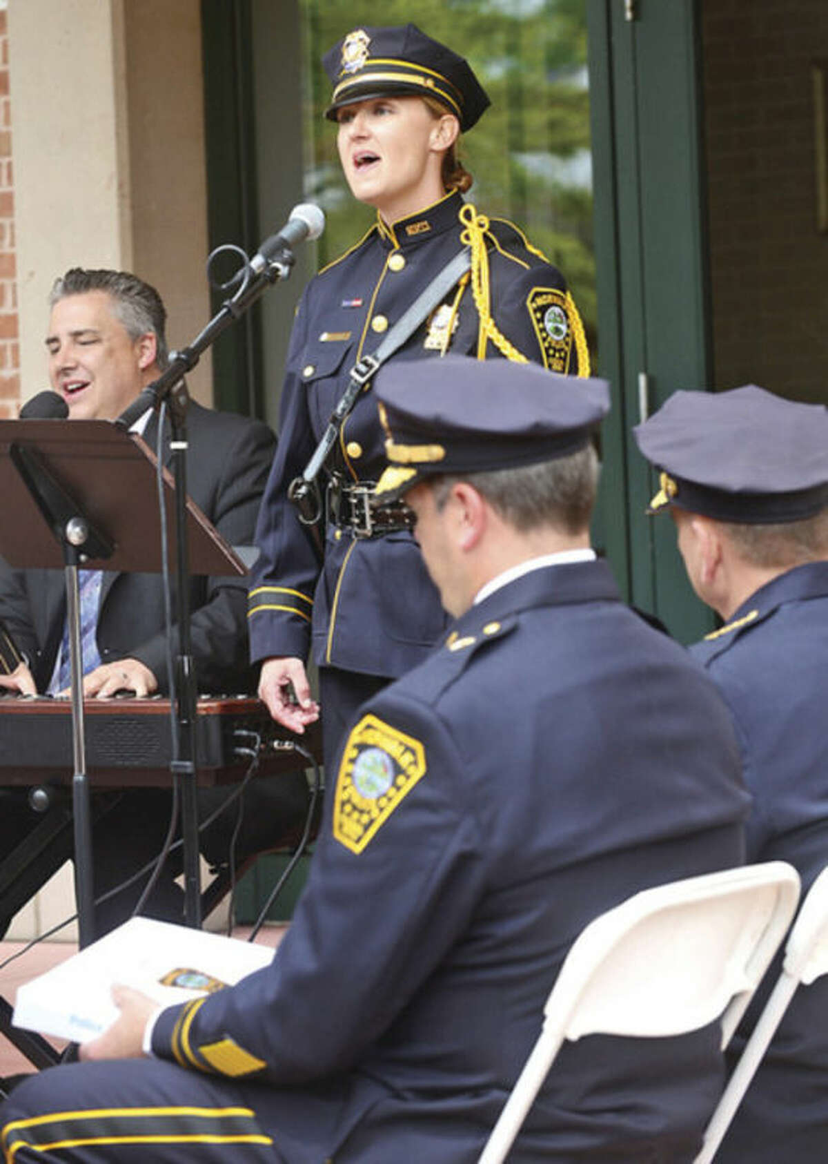 Norwalk police detective Kristina LaPak and David harris sing "The Prayer" as police and residents commemorate the officers who died in the line of duty during the Norwalk Department of Police Services annual Police Memorial Service Friday. Hour photo / Erik Trautmann