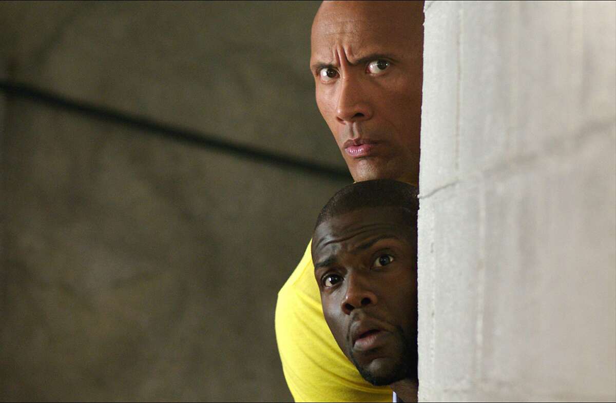 This image released by Warner Bros. Entertainment shows Kevin Hart, bottom, and Dwayne Johnson in a scene from, "Central Intelligence." (Claire Folger/Warner Bros. Entertainment Inc. via AP)