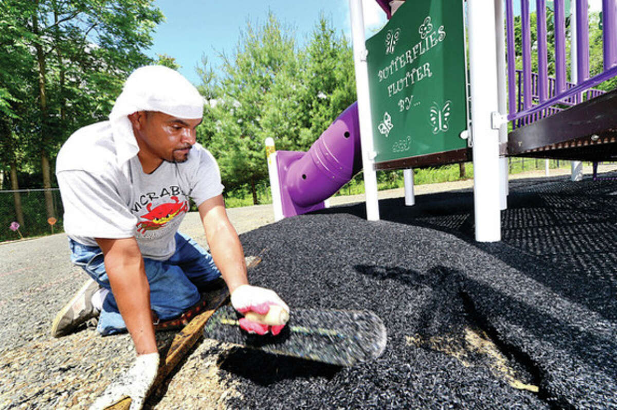 Hour photo / Erik Trautmann Giordano Construction worker Eloy Ruiz works on one of the "Where Angels Play" Sandy Hook playgrounds at Long Lots School in Westport. 26 playgrounds are being built as part of the project in honor of Sandy Hook victims.