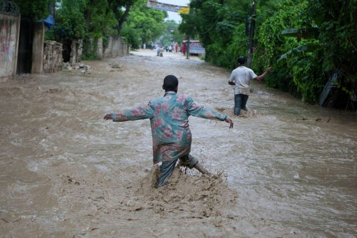 Residents wade through a flooded street caused by heavy rains from Hurricane Sandy in Port-au-Prince, Haiti, Thursday, Oct. 25, 2012. Hurricane Sandy rumbled across mountainous eastern Cuba and headed toward the Bahamas on Thursday as a Category 2 storm, bringing heavy rains and blistering winds. (AP Photo/Dieu Nalio Chery)
