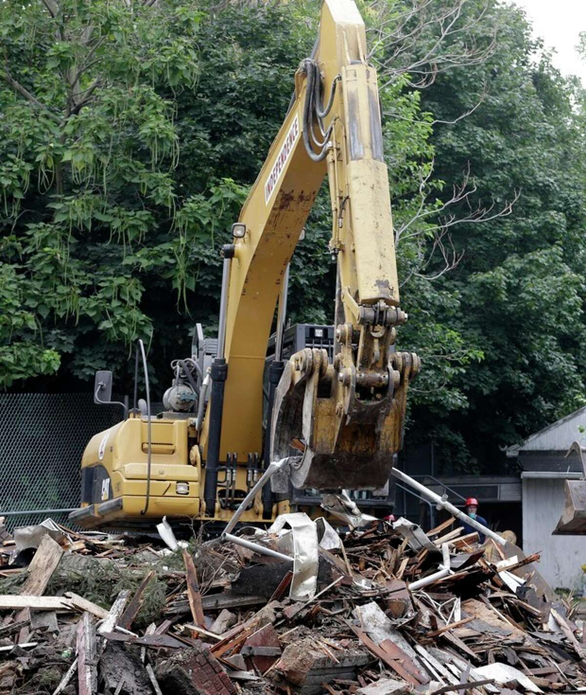 The house where three women were held captive and raped for more than a decade is demolished, Wednesday, Aug. 7, 2013, in Cleveland. Authorities want to make sure the rubble isn't sold online as "murderabilia," though no one died there. The house was torn down as part of a deal that spared Ariel Castro a possible death sentence. He was sentenced last week to life in prison plus 1,000 years. Castro apologized but blamed his addiction to pornography. (AP Photo/Tony Dejak)