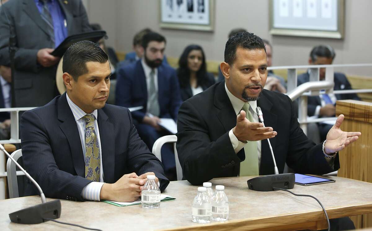 FILE-- Craig DeLuz, right, legislative advocate for the gun rights group, Firearms Policy Coalition, urges lawmakers to reject a measure by by Assembly Miguel Santiago, D-Los Angeles, left, that would ban the purchase of more than one long gun within a 30-day period, during a hearing of the Senate Public Safety Committee, Tuesday, June 14, 2016, in Sacramento. The Firearms Policy Coalition is funding a suit against state Legislative Counsel Diane Boyer-Vine, that accuses state officials of using an “unusual and unconstitutional” law to censor what its chief says is legitimate free speech.