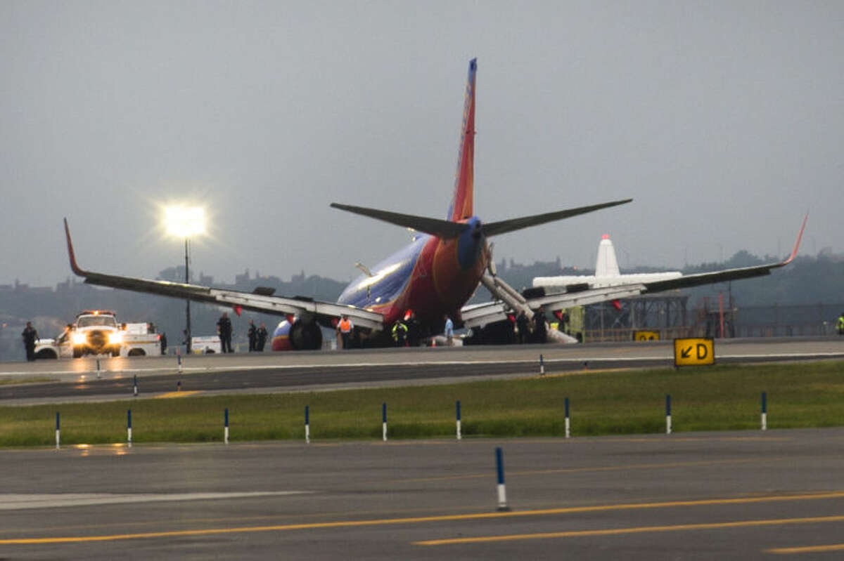 A southwest airlines plane rests on the tarmac after what officials say was a nose gear collapse during a landing at LaGuardia Airport, Monday, July 22, 2013, in New York. The Federal Aviation Administration says the plane landed safely. (AP Photo/John Minchillo)