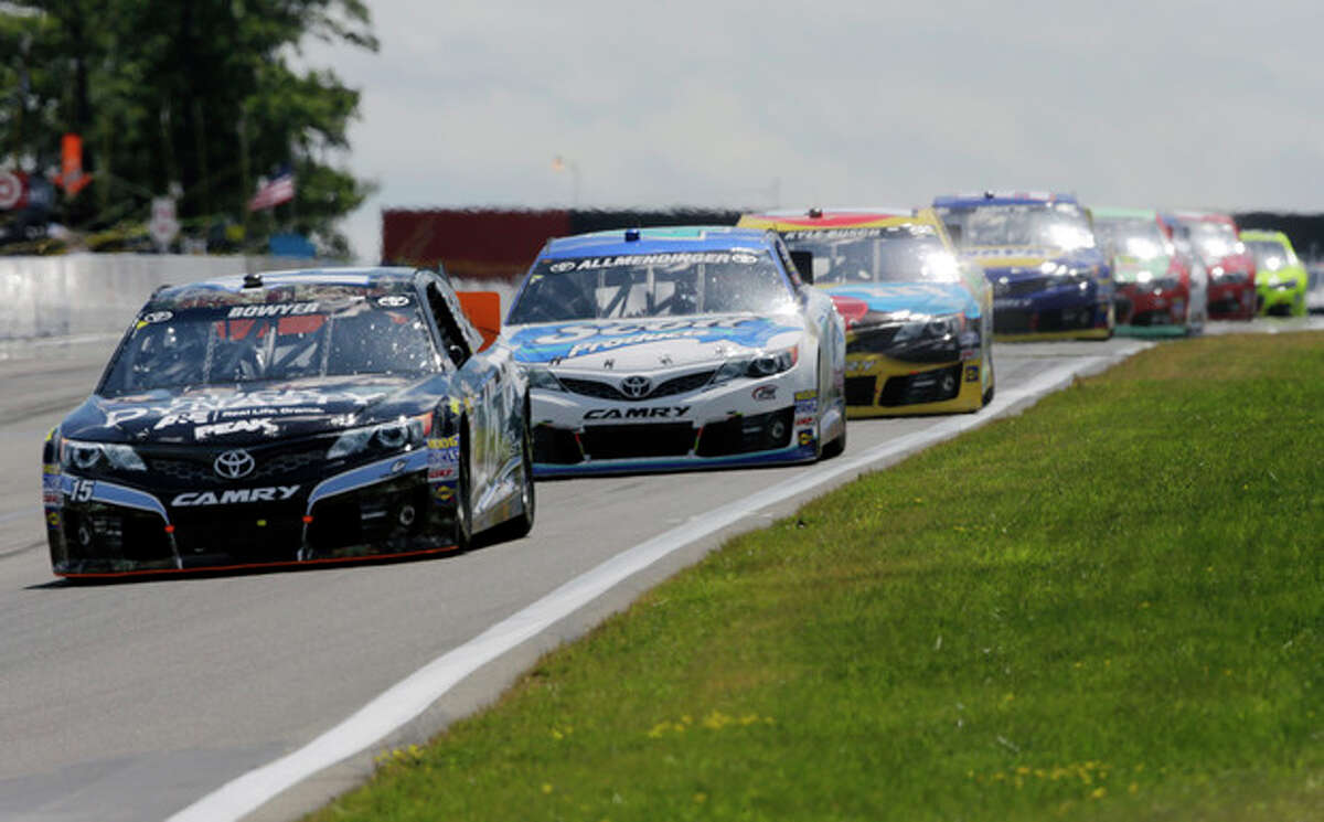 Clint Bowyer (15) leads a group of racers during a NASCAR Sprint Cup Series auto race at The Glen Sunday, Aug. 11, 2013, in Watkins Glen, N.Y. (AP Photo/Mel Evans)