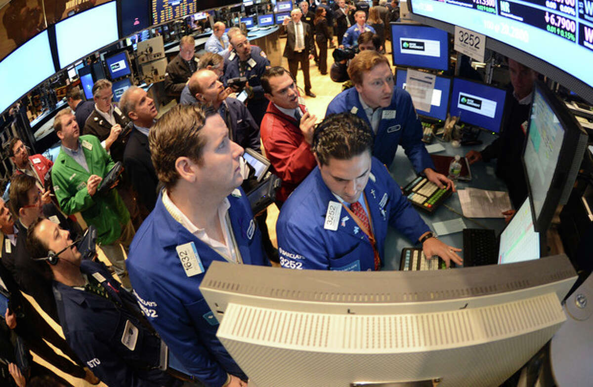 FILE - In this Thursday, Nov. 8, 2012, file photo, Gregg Maloney, left, and Ronnie Howard, center, both of Barclays, direct trading on the floor of the New York Stock Exchange, in New York U.S. stocks eked out the tiniest of gains on Monday Nov. 12, 2012, small comfort after worries about the fiscal cliff sent the market plunging last week. (AP Photo/Henny Ray Abrams)