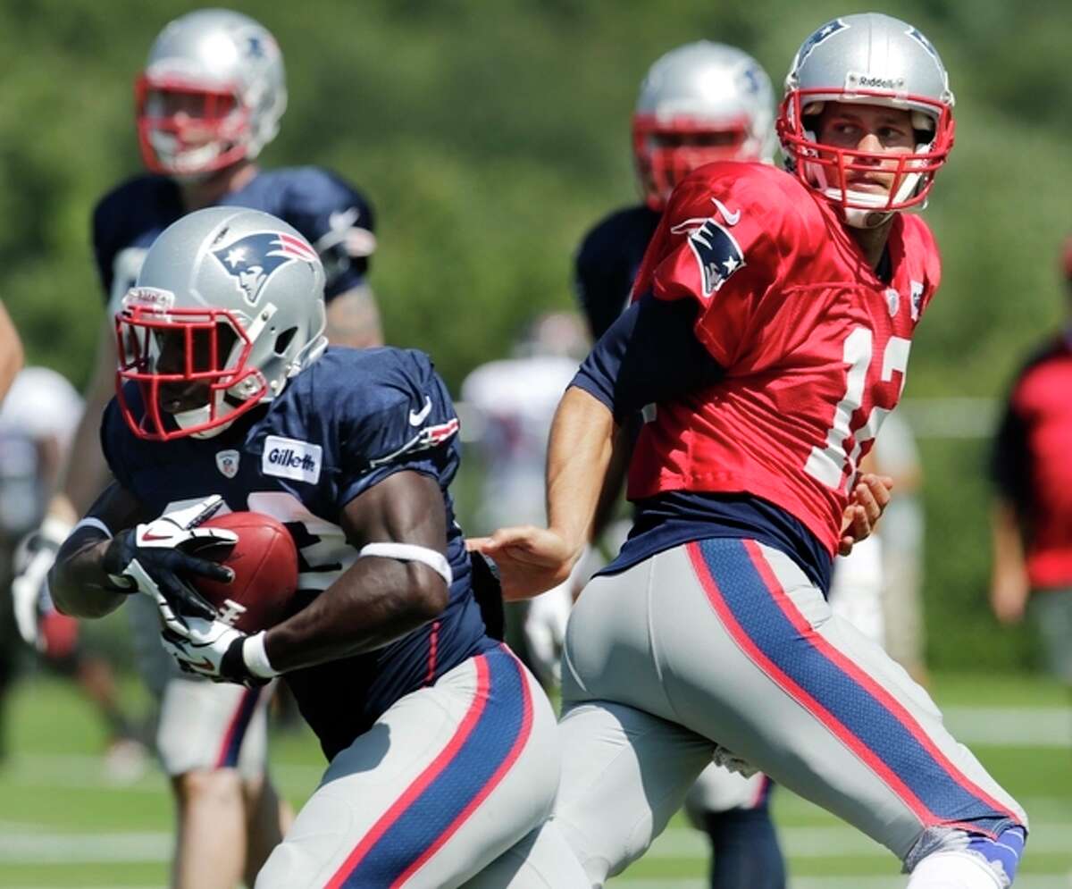 New England Patriots quarterback Tom Brady, right, hands off to running back Leon Washington during a joint workout with the Tampa Bay Buccaneers at NFL football training camp, in Foxborough, Mass., Wednesday, Aug. 14, 2013. (AP Photo/Charles Krupa)