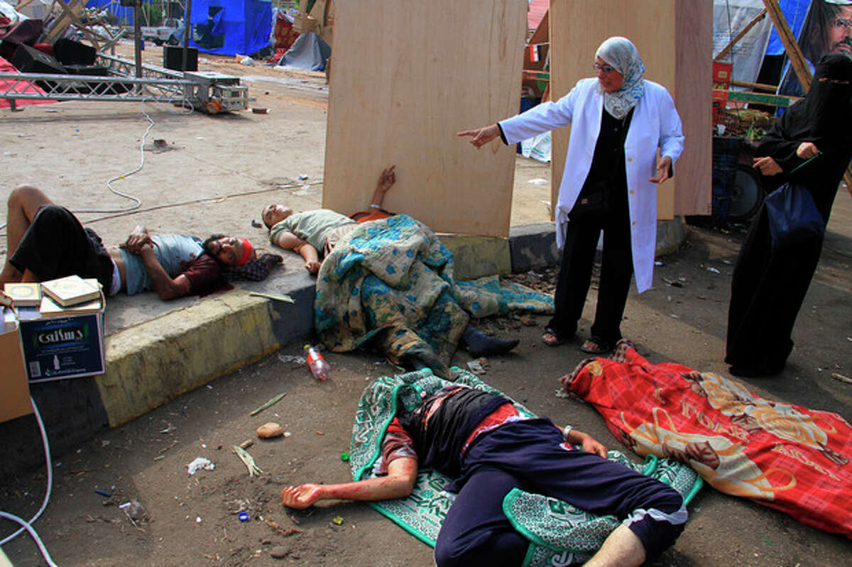 Injured supporters of ousted Islamist President Mohammed Morsi lie on the ground after Egyptian security forces clear a sit-in camp set up by supporters of Morsi in Nasr City district, Cairo, Egypt, Wednesday, Aug. 14, 2013. Egyptian security forces, backed by armored cars and bulldozers, moved on Wednesday to clear two sit-in camps by supporters of the country's ousted President Mohammed Morsi, showering protesters with tear gas as the sound of gunfire rang out at both sites. (AP Photo/Ahmed Gomaa)