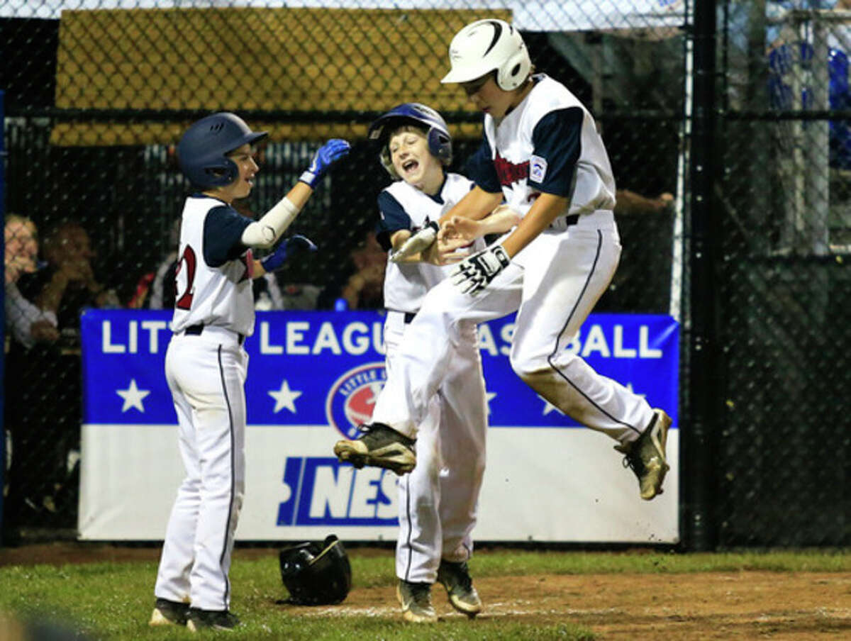 Hour photo/Chris Palermo Westport's Chad Knight leaps into fellow teammates after scoring a run during the Little League Baseball New England Regional Tournament against South Burlington, Vt., on Aug. 2, 2013 at the Giamatti Little League Center in Bristol. Westport has advanced all the way to the Little League World Series in South Williamsport, Pa.