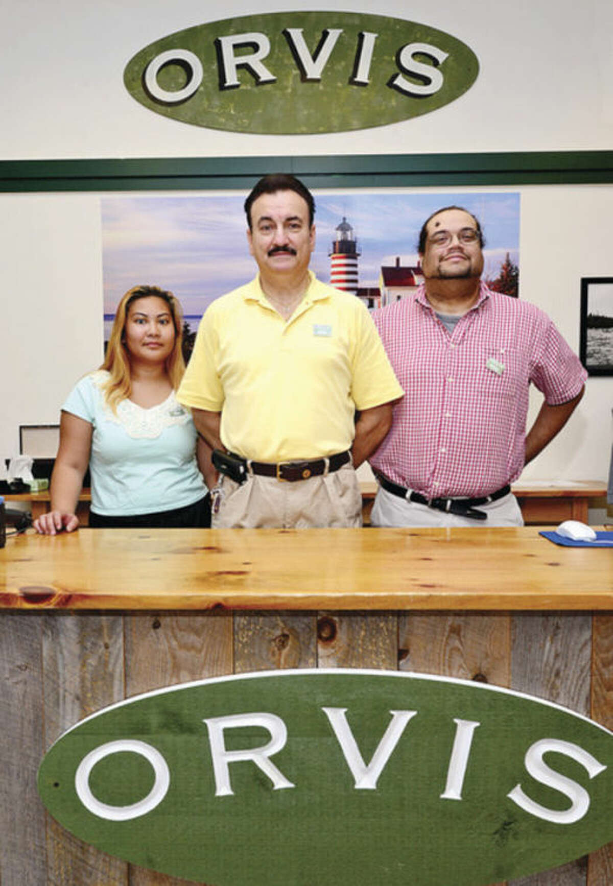 Store manager Nick Douglas flanked by key holders Rita Khongmany and Phil Taliaferro a the new Orvis location on Westport Avenue in Norwalk. Hour photo / Erik Trautmann