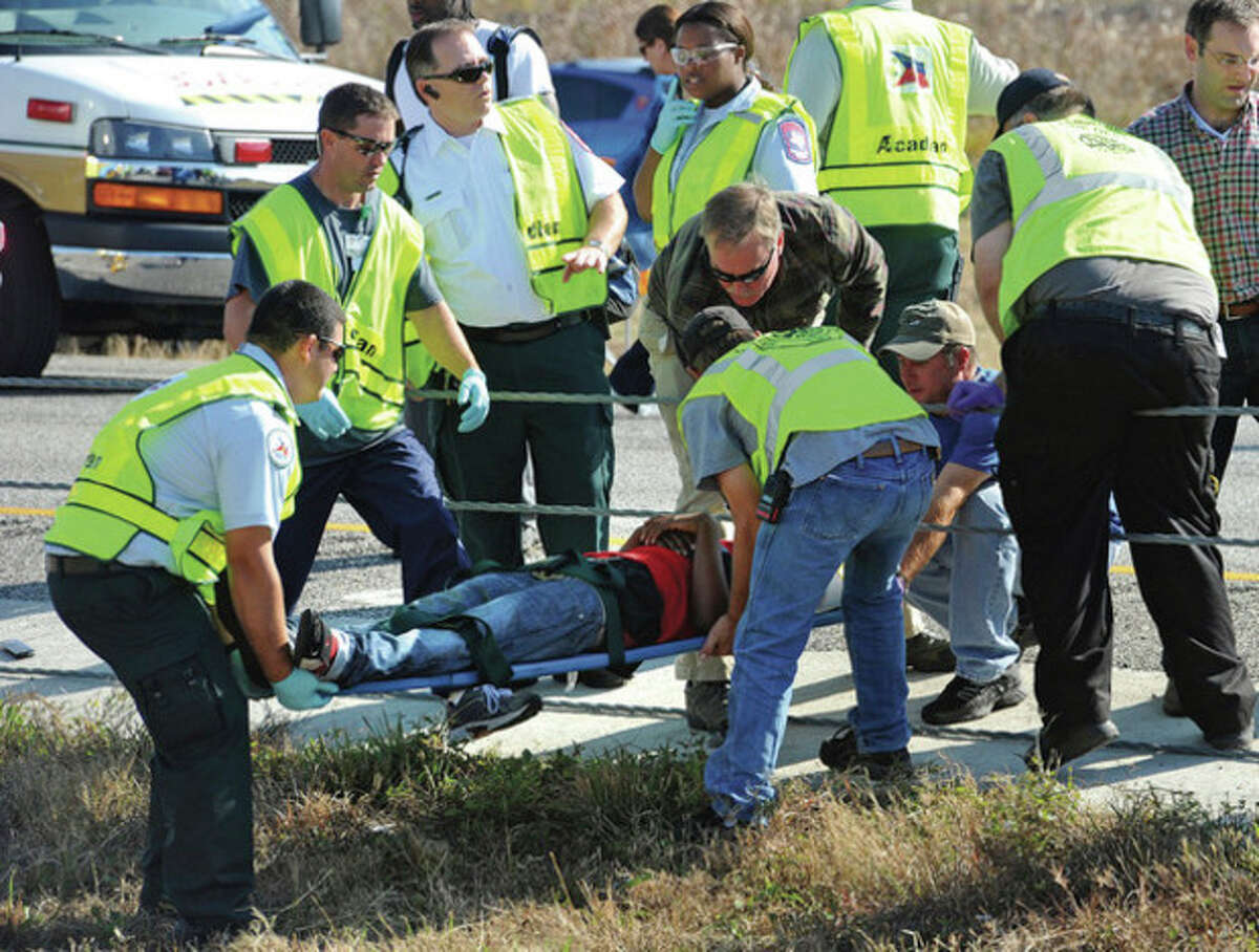 Emergency workers carry a victim across the Interstate 10 median after a massive auto accidentin Southeast Texas Thursday Nov. 22, 2012. The Texas Department of Public Safety says at least 35 people have been injured in a more than 50-vehicle pileup. (AP Photo/The Beaumont Enterprise, Guiseppe Barranco)