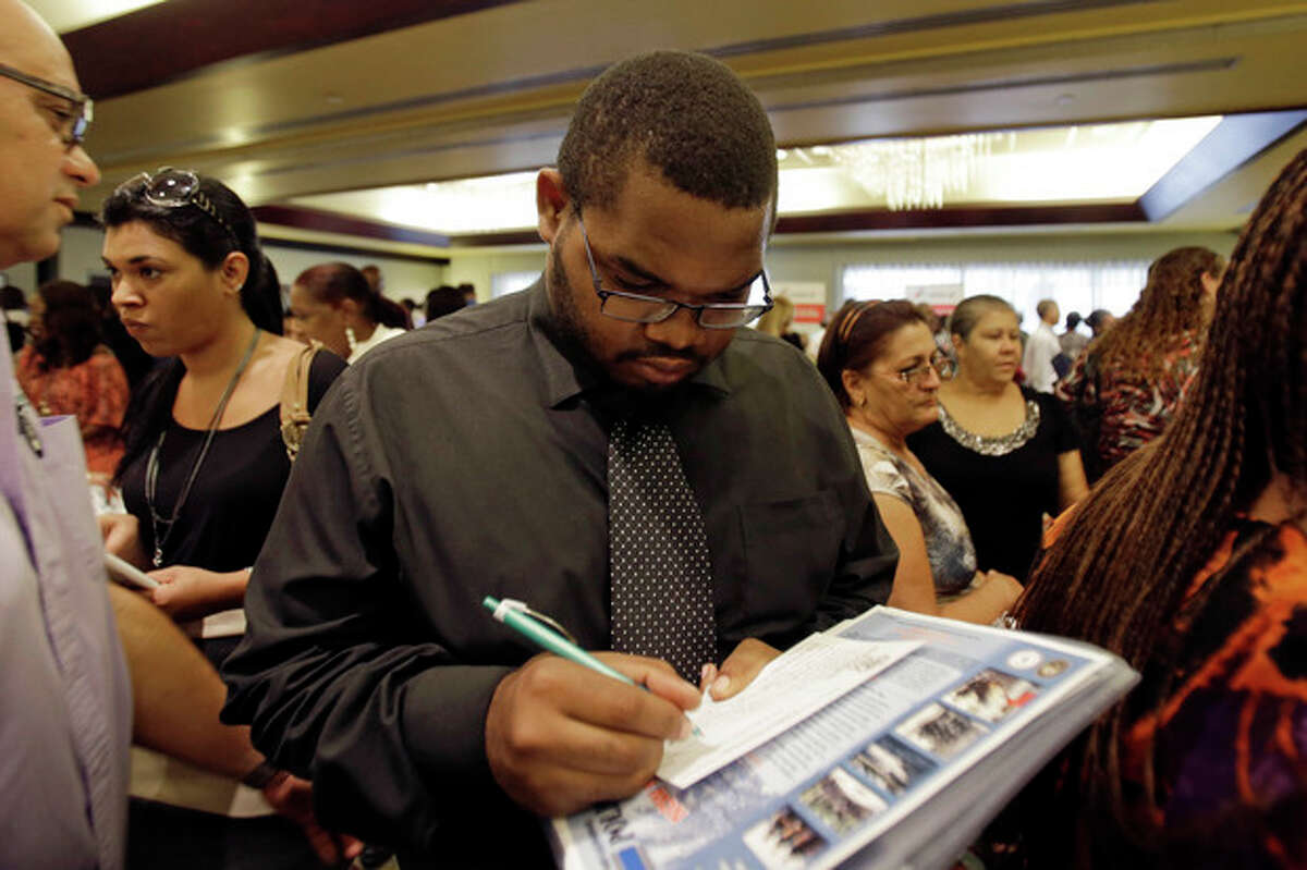 In this Wednesday, Aug., 14, 2013, photo, job seeker Kelsey Devoe, of Miramar, Fla., fills out a contact form at a job fair in Miami Lakes, Fla. The Labor Department reports on the number of Americans who applied for unemployment benefits last week on Thursday, Aug. 15, 2013. (AP Photo/Alan Diaz)