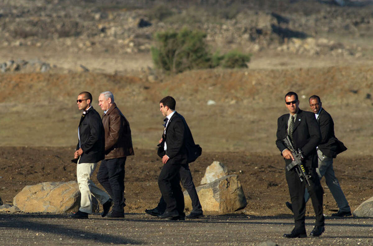 FILE- In this Nov. 14, 2012, file photo, Israeli Prime Minister Benjamin Netanyahu, second left, is surrounded by bodyguards as he walks towards a military helicopter following a visit to the Golan Heights. After seven years in power, Natanyahu has pulled the trigger, unleashing a massive offensive against Gaza rocket-launchers. The public and even his political opponents have all lined up behind him and barring a fiasco involving heavy Israeli casualties, Netanyahu should coast to victory in the upcoming Israeli elections. (AP Photo/Hamad Almakt, File)