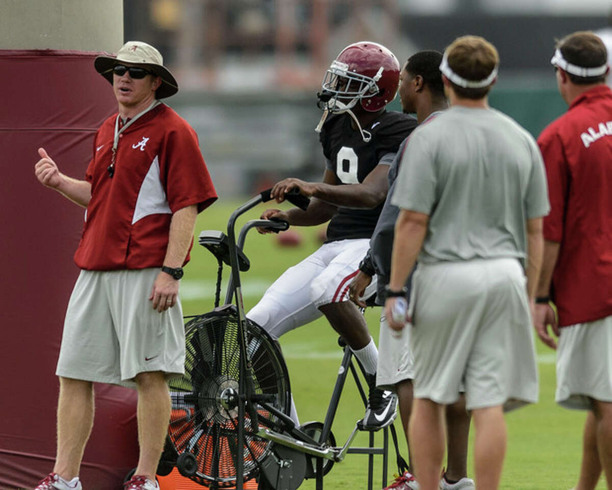 Scott Cochran, Alabama director of strength and conditioning, chats with wide receiver Amari Cooper (9) as Cooper continues rehabilitation on his foot during the NCAA college football team's practice, Thursday, Aug. 15, 2013, in Tuscaloosa, Ala. (AP Photo/AL.com, Vasha Hunt) MAGS OUT