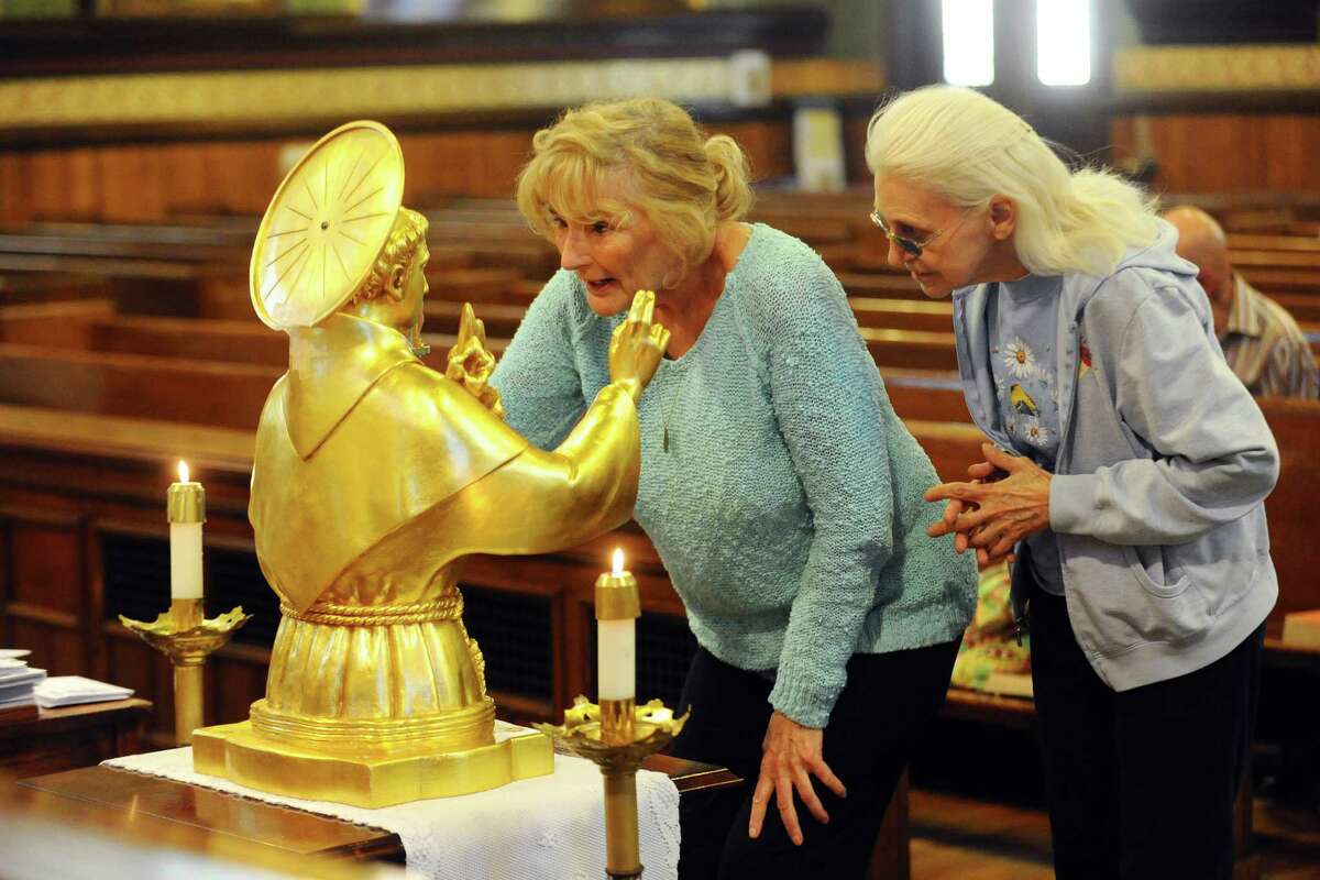 Elaine Hevenor (center), of Greenwich, and Rose Marie Briganti, of Cos Cob, lean in close to get a good look at the Relic of St. Anthony of Padua inside the Basilica of St. John the Evangelist in Stamford, Conn. on Tuesday, June 14, 2016.