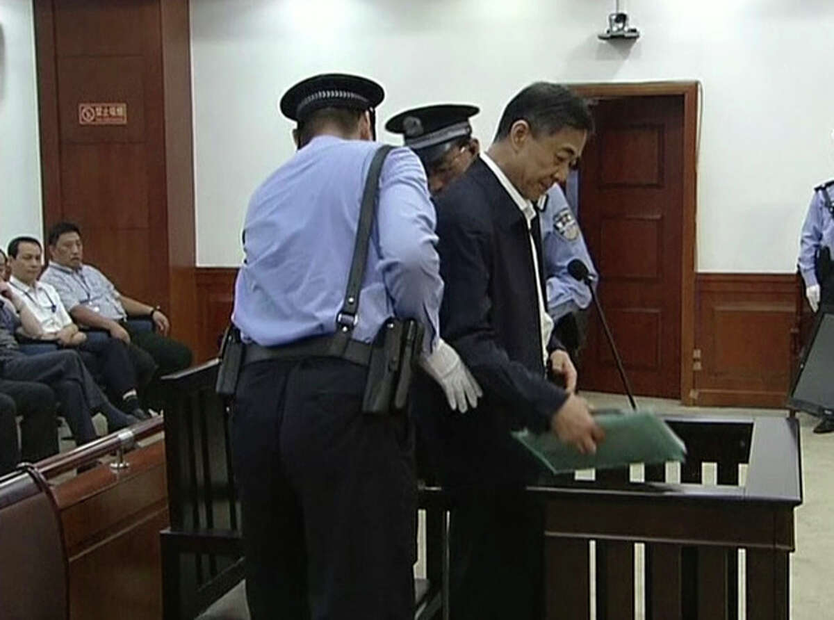 In this image taken from video, former Chinese politician Bo Xilai, center, is escorted by court guards before he sits at a defendant's seat for his trial at Jinan Intermediate People's Court in Jinan, eastern China's Shandong province, Sunday, Aug. 25, 2013. Bo on Sunday sought to discredit his former top aide as a lying, unreliable witness as the ousted leader denied criminal responsibility in the country's messiest political scandal in decades.decades. (AP Photo/CCTV via AP Video) CHINA OUT, TV OUT