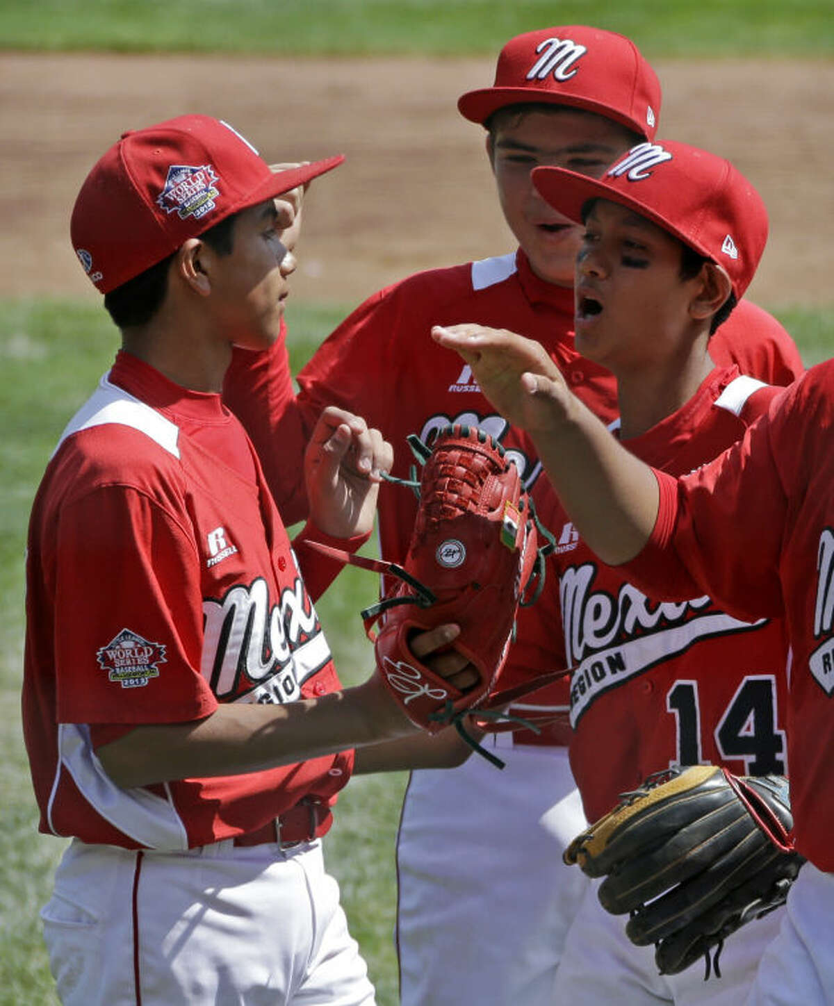 Tijuana, Mexico, pitcher Martin Gonzalez, left, celebrates with teammates Miguel Artalejo, center, and Brandon Montes (14) after getting the final out of a 15-14 win over Westport, Conn., in a consolation baseball game at the Little League World Series tournament in South Williamsport, Pa., Sunday, Aug, 25, 2013. (AP Photo/Gene J. Puskar)