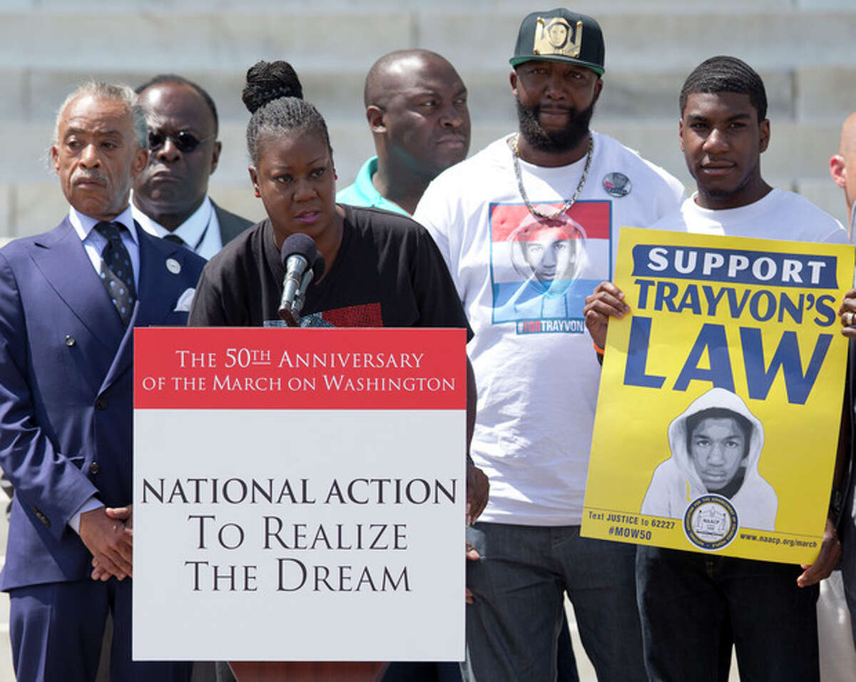 Sabrina Fulton, mother of slain teenager Trayvon Martin, speaks at the podium in front of the Lincoln Memorial in Washington Saturday, Aug. 24, 2013, with Rev. Al Sharpton, left, Tracy Martin, father of Trayvon Martin, second from right, and Jahvaris Fulton, brother of Trayvon Martin, right, during the 50th anniversary commemoration of the of the Aug. 28, 1963, March on Washington. (AP Photo/Carolyn Kaster)