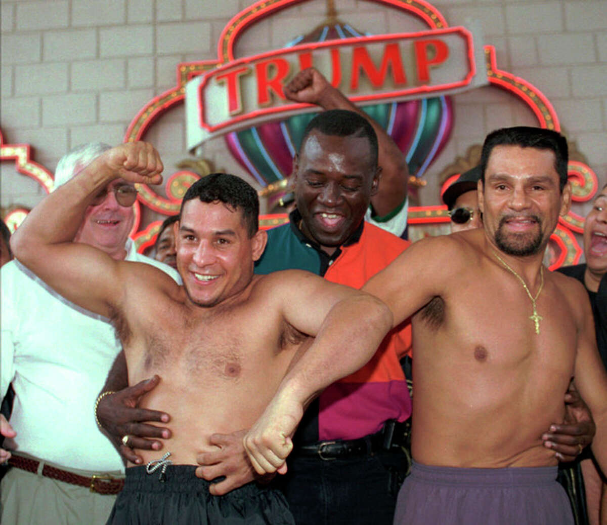 FILE - In this June 21, 1996 file photo, after a ceremonial weigh-in, Panamanian Roberto Duran, right, reaches for the stomach of boxing champ Hector "Macho" Camacho, left, who tries to elbow Duran's hand away at the Trump Taj Mahal Casino Resort in Atlantic City, N.J. Camacho, a boxer known for skill and flamboyance in the ring, as well as for a messy personal life and run-ins with the police, has died, Saturday, Nov. 24, 2012, after being taken off life support. He was 50. (AP Photo/Charles Rex Arbogast, File)