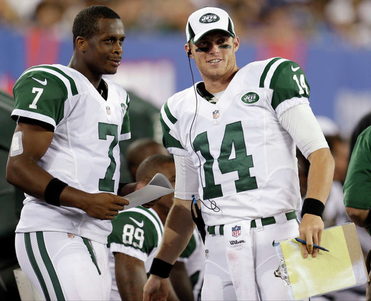 New York Jets quarterbacks Geno Smith (7) and Greg McElroy (14) talk during the first half of a preseason NFL football game against the New York Giants, Saturday, Aug. 24, 2013, in East Rutherford, N.J. (AP Photo/Julio Cortez)