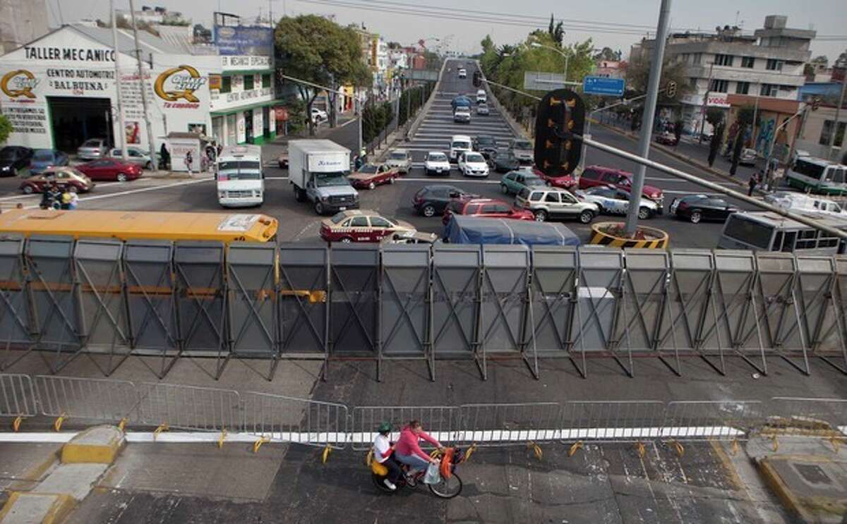 The street where Mexico's Congress is located is shown blocked by a metal barricade in Mexico City, Monday, Nov. 26, 2012. Police heightened security around the building where Mexico's President-elect Enrique Pena Nieto, of the Institutional Revolutionary Party (PRI) will be sworn-in on Dec. 1. (AP Photo/Eduardo Verdugo)